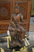 An 18th century carved wood seated Buddha with traces of painted decoration.