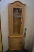 A limed oak standing corner cabinet.