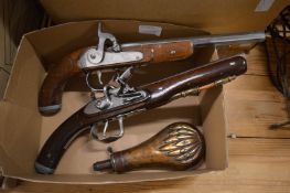 Two replica pistols and a copper shot or powder flask.