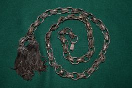 A decorative white metal curb link belt.