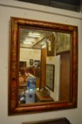 Decoratively framed wall mirror.