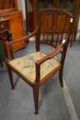 An Edwardian inlaid mahogany elbow chair.