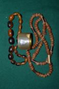 Amber bead necklace, a horn necklace and a horn napkin ring.