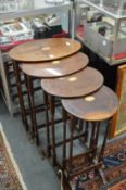 A nest of four oval mahogany tables with inlaid decoration.