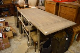 An Oka grey stained pine drop-flap dining table.