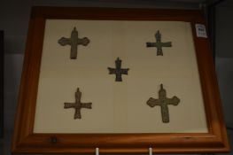 A group of bronze crosses, framed.