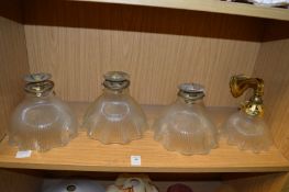 A set of three brass and cut glass ceiling lights and a matching wall light.