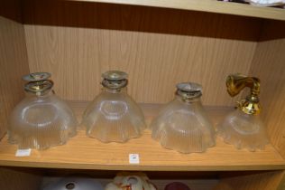 A set of three brass and cut glass ceiling lights and a matching wall light.