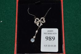 A pretty diamond set bow shaped pendant and chain with aquamarine drop.