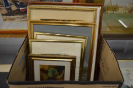 A box of various paintings and prints.