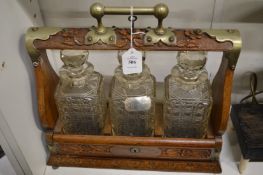 An oak tantalus with plated mounts.