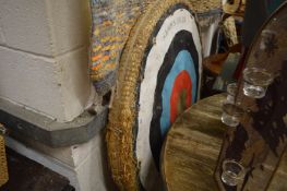 A Jaques archery target with stand and pair of bows.