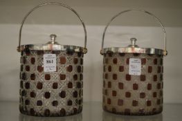 A pair of glass biscuit barrels with plated mounts.