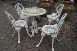 A cream painted aluminium circular patio table and four chairs.