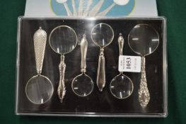 A cased set of six miniature magnifying glasses.