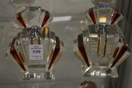 A pair of Art Deco style amber tinted glass scent bottles.