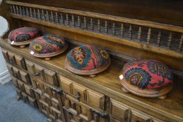 A set of four upholstered circular footstools.
