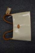A Tod's cream and tan leather handbag with outer cover.