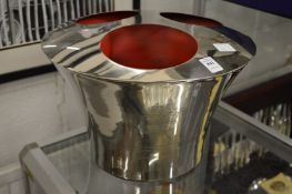 A polished metal three bottle wine cooler.