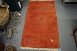 A small red ground rug, 140cm x 75cm.