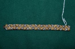 A yellow metal and gem set bracelet set with flower head decoration, stamped 750.