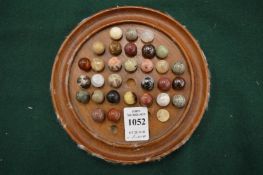 Solitaire board and small collection of marbles.