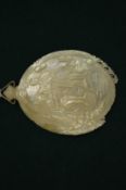 A carved shell pendant.