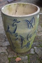 A tall terracotta planter with incised decoration.
