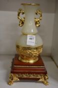 An Oriental gilt metal mounted onyx vase on stand.