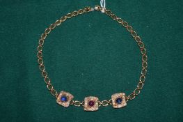 A yellow metal and gem set necklace.