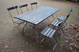 A wooden and galvanised steel trestle style rectangular garden table with six matching folding