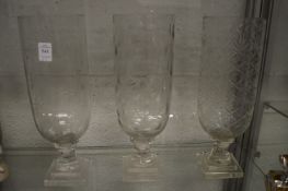 Three glass storm lanterns.