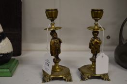 A small pair of brass figural candlesticks.