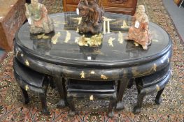 A Chinese black lacquer oval coffee table with glass top protecting an onlaid and inlaid