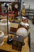A table lamp, a globe lamp and a cased set of books.