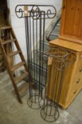 A pair of wrought iron ionic column style stands.