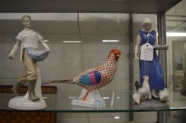 A Herend cock pheasant together with a B & G figure of a lady feeding chickens and another figure.