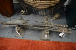 Brass firedogs and four fireside tools.