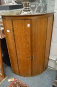 A 19th century oak bow front two door hanging cupboard.