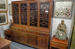 A Chinese redwood library bookcase with four glazed doors above four drawers and four panelled