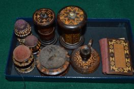 Tunbridge ware, four pin cushions, two thread holders, a miniature chamber stick and a needle case.