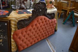 A carved pine and upholstered headboard.