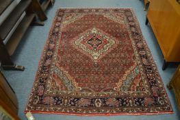 A Persian design rug, red ground with stylised decoration, 212cm x 142cm.