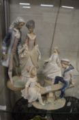 Three large Lladro figures, boy and a girl on a seesaw and two others.