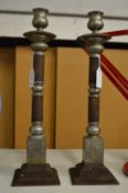 A pair of Chinese cast metal candlesticks.