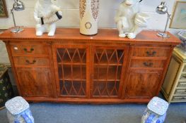 A Georgian style yew wood side cabinet with a pair of central glazed doors flanked by small