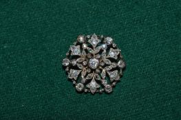 A gold and diamond set circular flower head brooch.