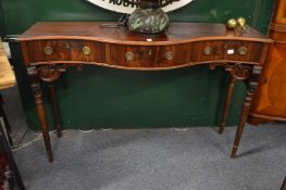 A mahogany serpentine fronted three drawer side table.