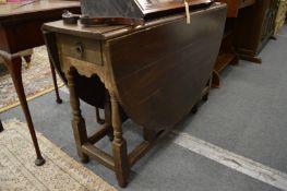 An oak drop-leaf gateleg dining table.
