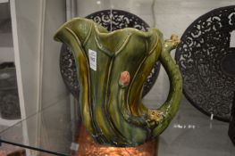 An unusual naturalistically styled pottery jug, the handled mounted with little frogs.